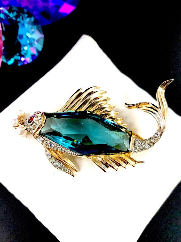 Hexagon sapphire blue glass stone at the center of the fish